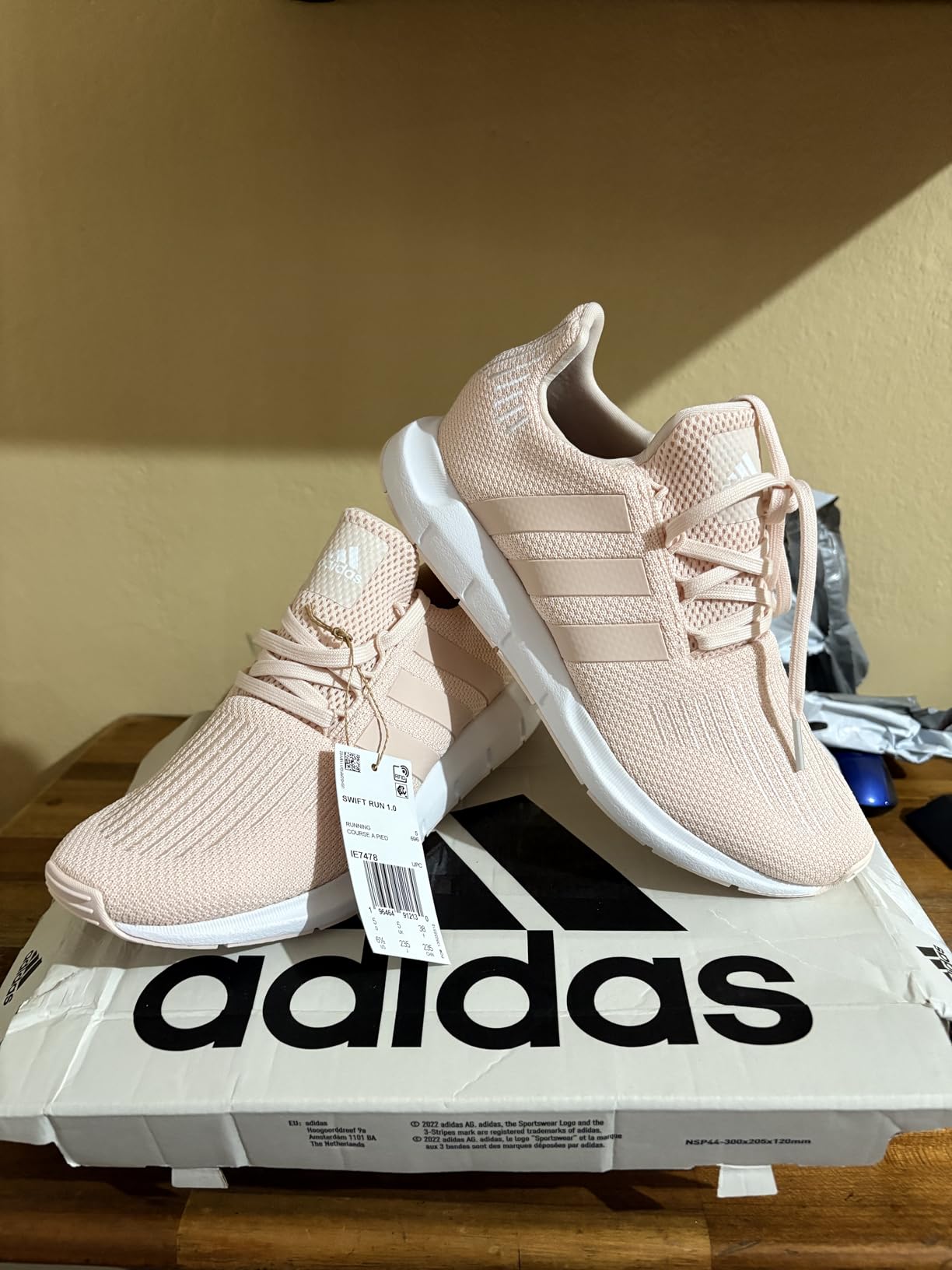 Adidas Swift Run knit upper construction details showing breathable textile and embroidered three stripes