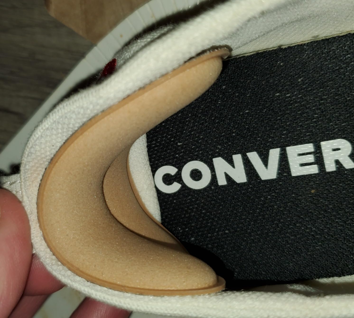 Nude colored heel pads being applied to light colored shoes demonstrating color matching