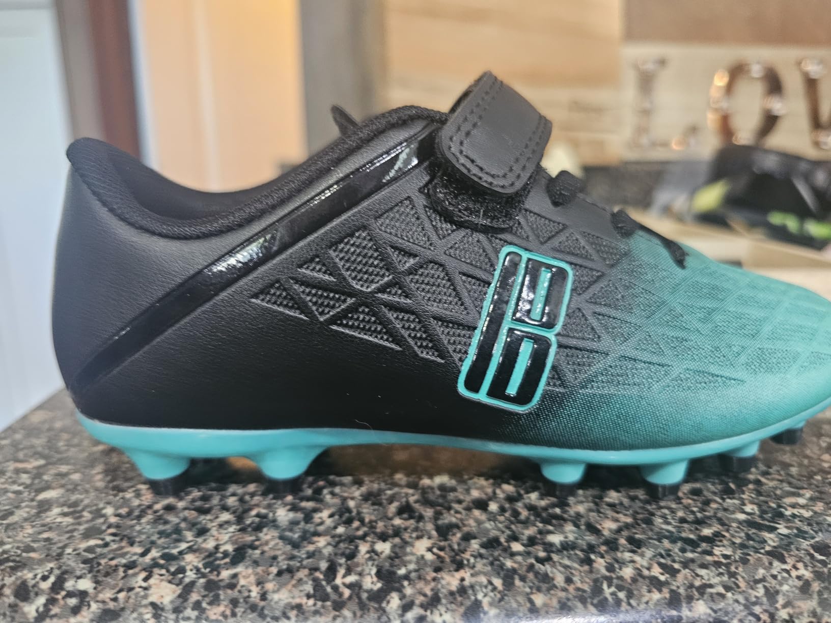 Side view of brooman kids soccer cleats showing overall construction and ankle support