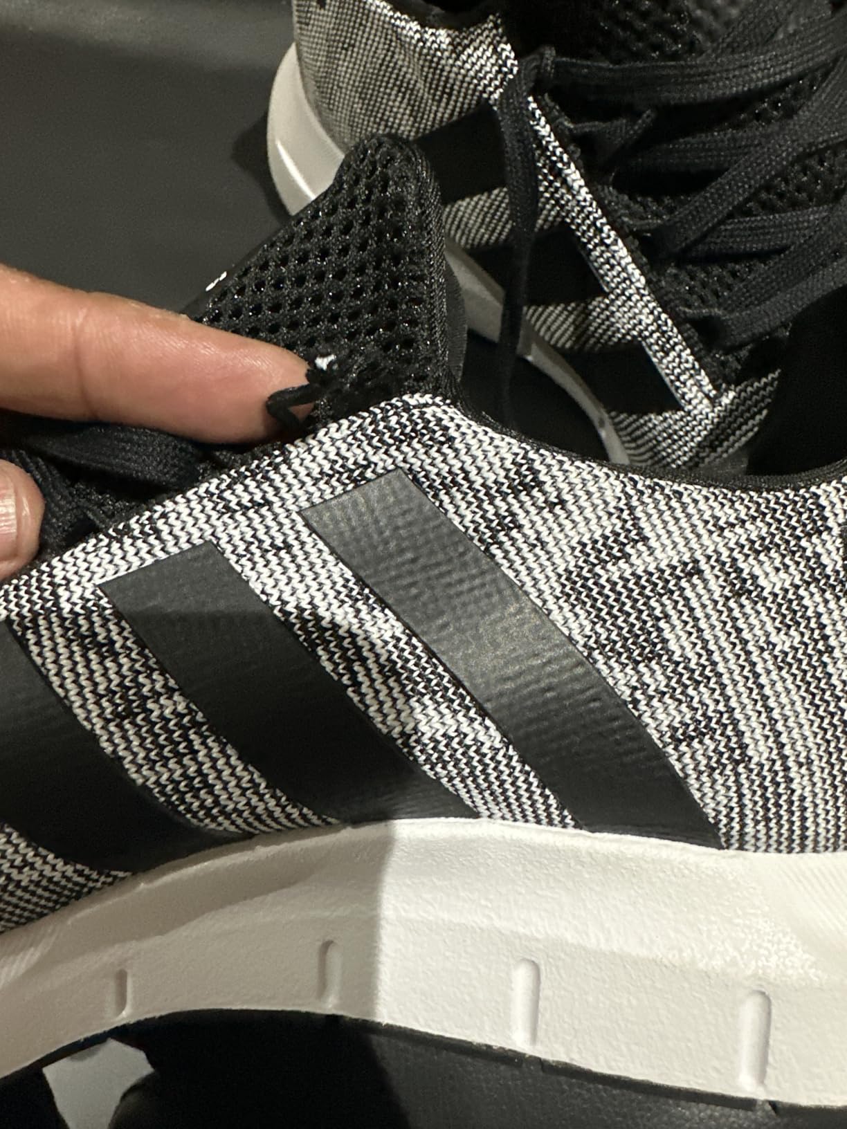 Adidas Swift Run detail shot showing elastic mesh upper construction and minimalist design