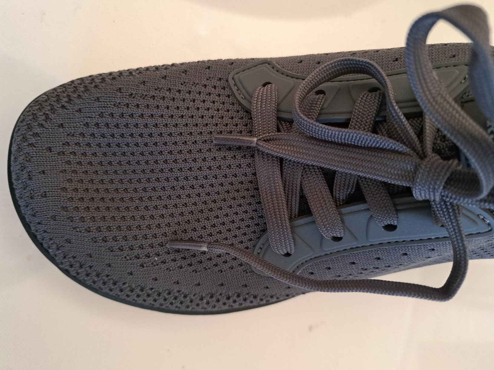 Close-up detail of L-RUN shoe construction showing knit upper material and lace system