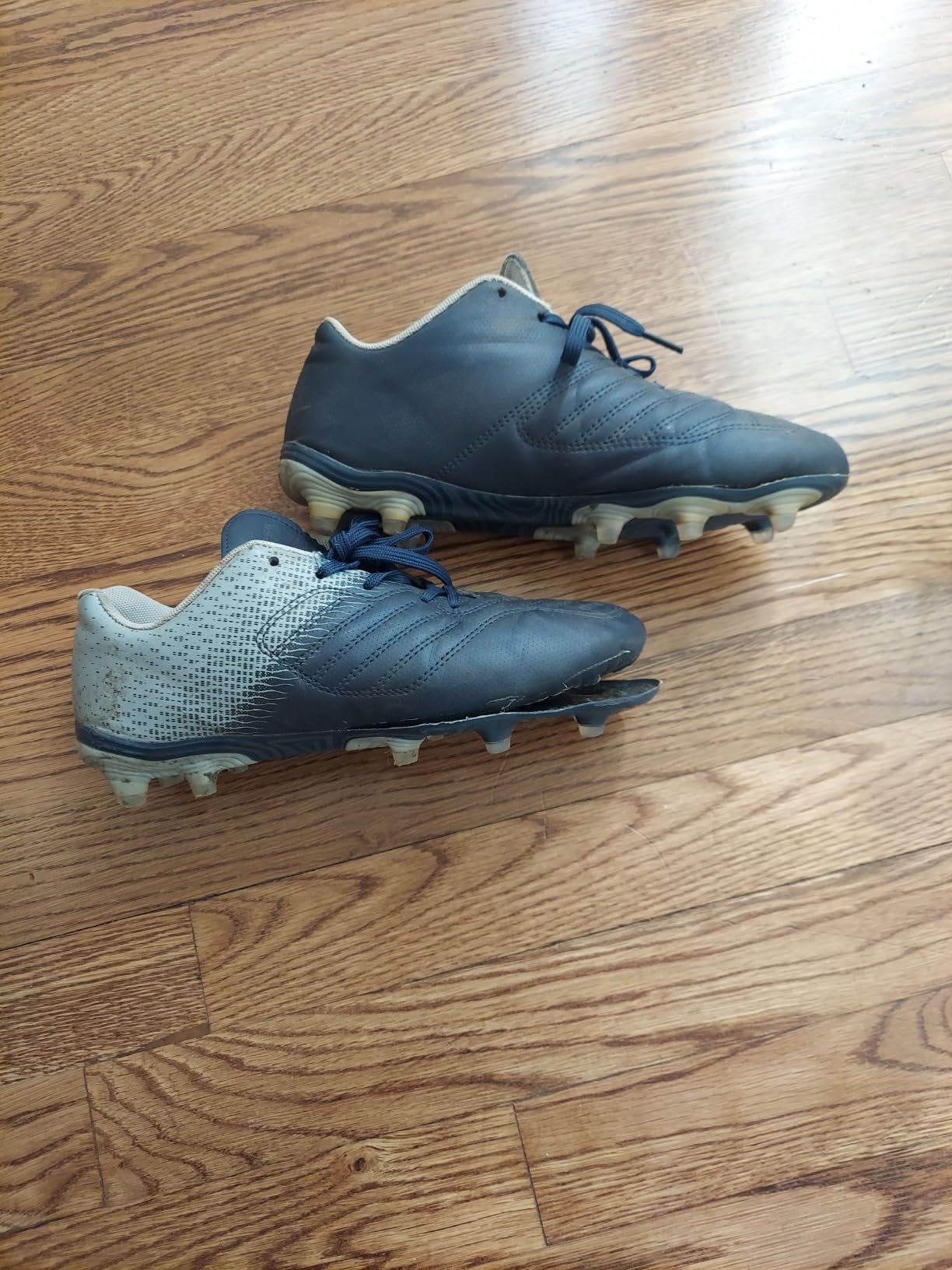 brooman kids soccer cleats navy grey colorway showing lace-up design and firm ground sole pattern