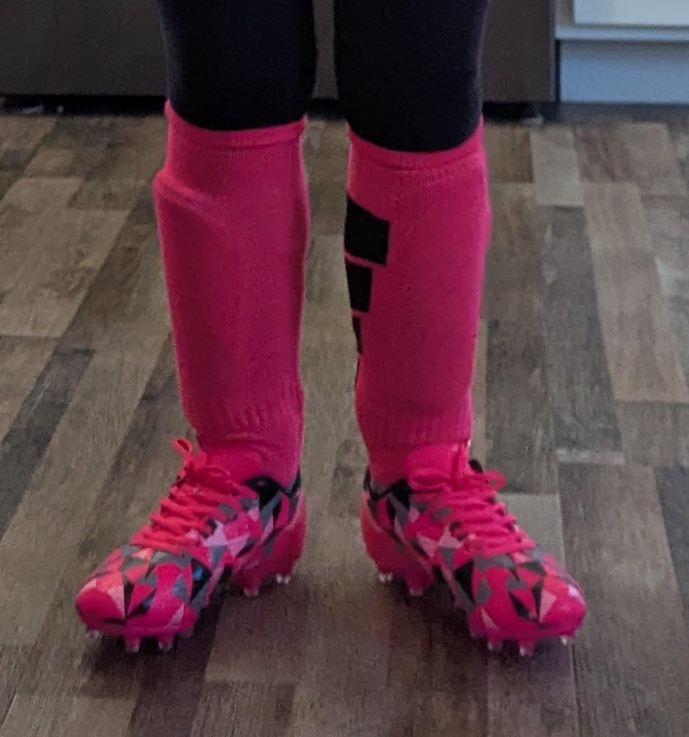 Young girl wearing MIFAWA soccer cleats while playing on a green grass field