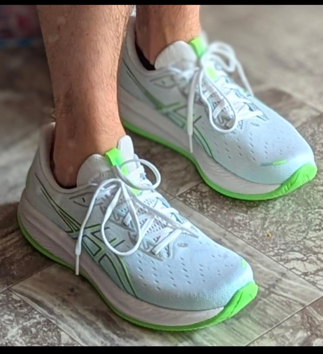 ASICS Gel-Cumulus 26 orange colorway side profile showing midsole technology and outsole tread pattern