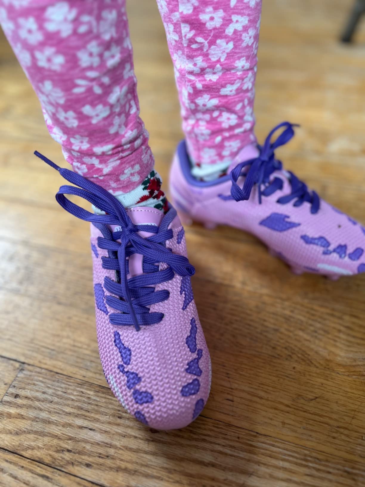 DREAM PAIRS soccer cleats showing studded outsole pattern and protective heel design on grass field