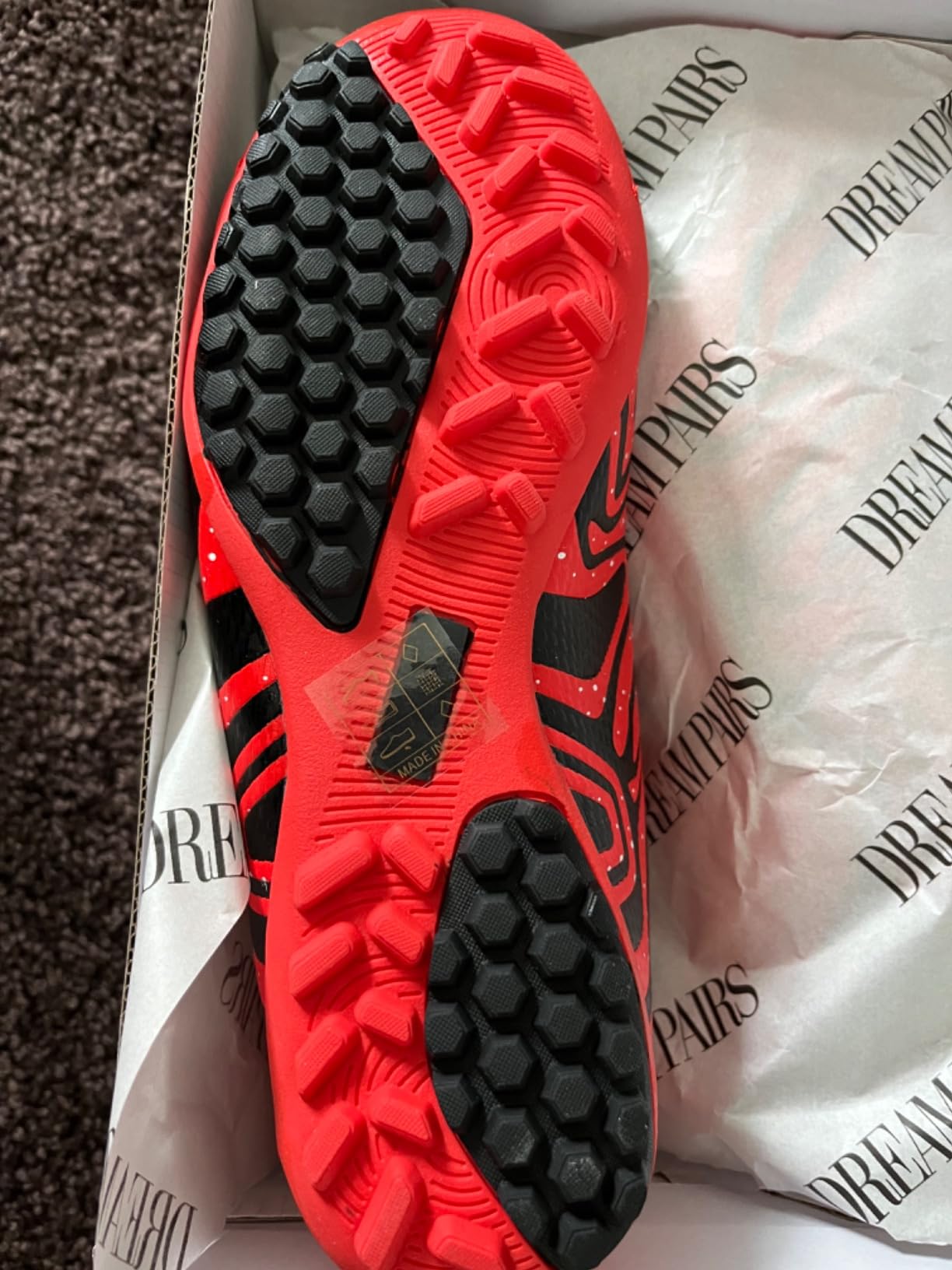 Close-up view of DREAM PAIRS soccer cleat construction showing textured upper and TF studs