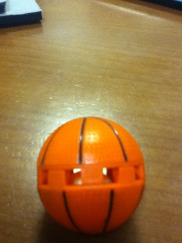 Close-up of sneaker ball showing twist mechanism and vent holes for scent release