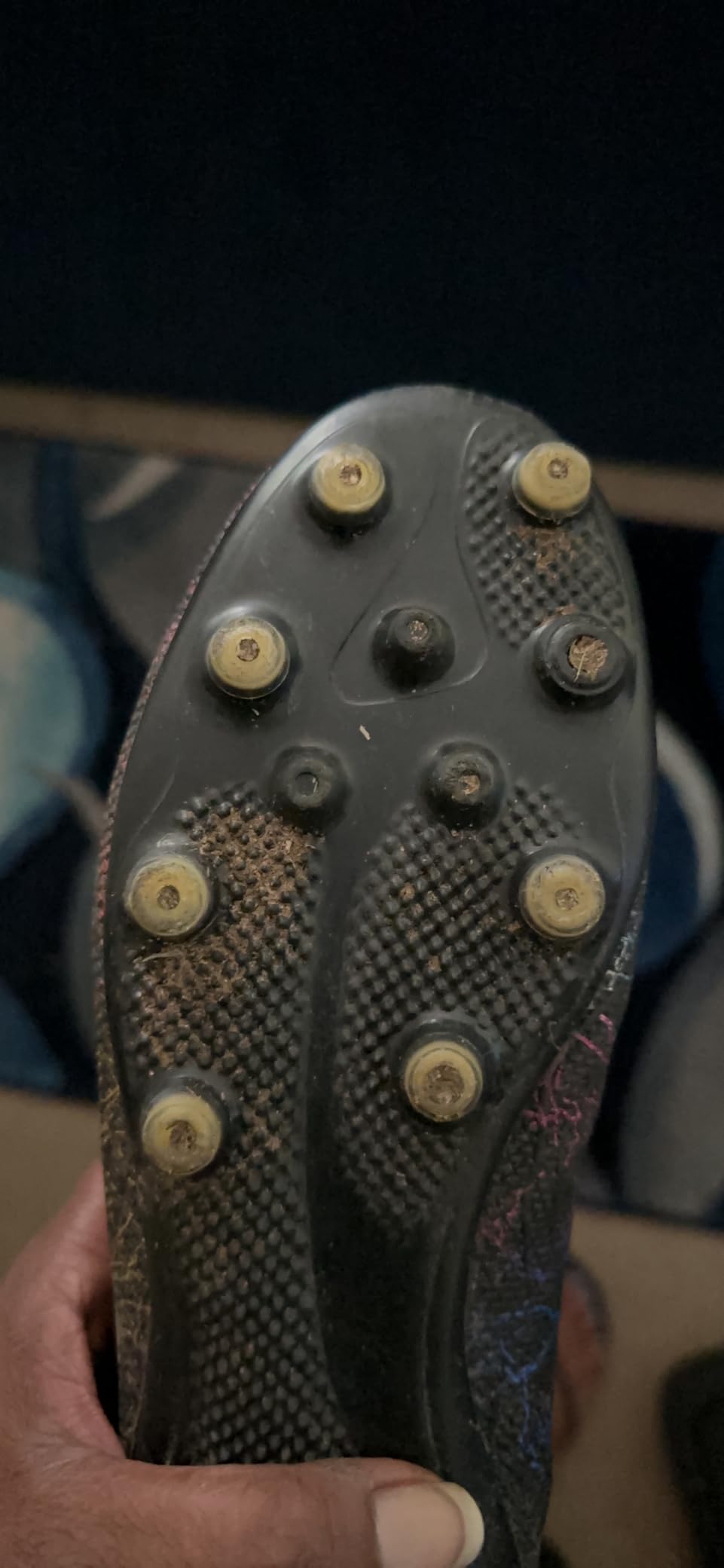 Close-up showing wear on soccer cleat spikes after extended use
