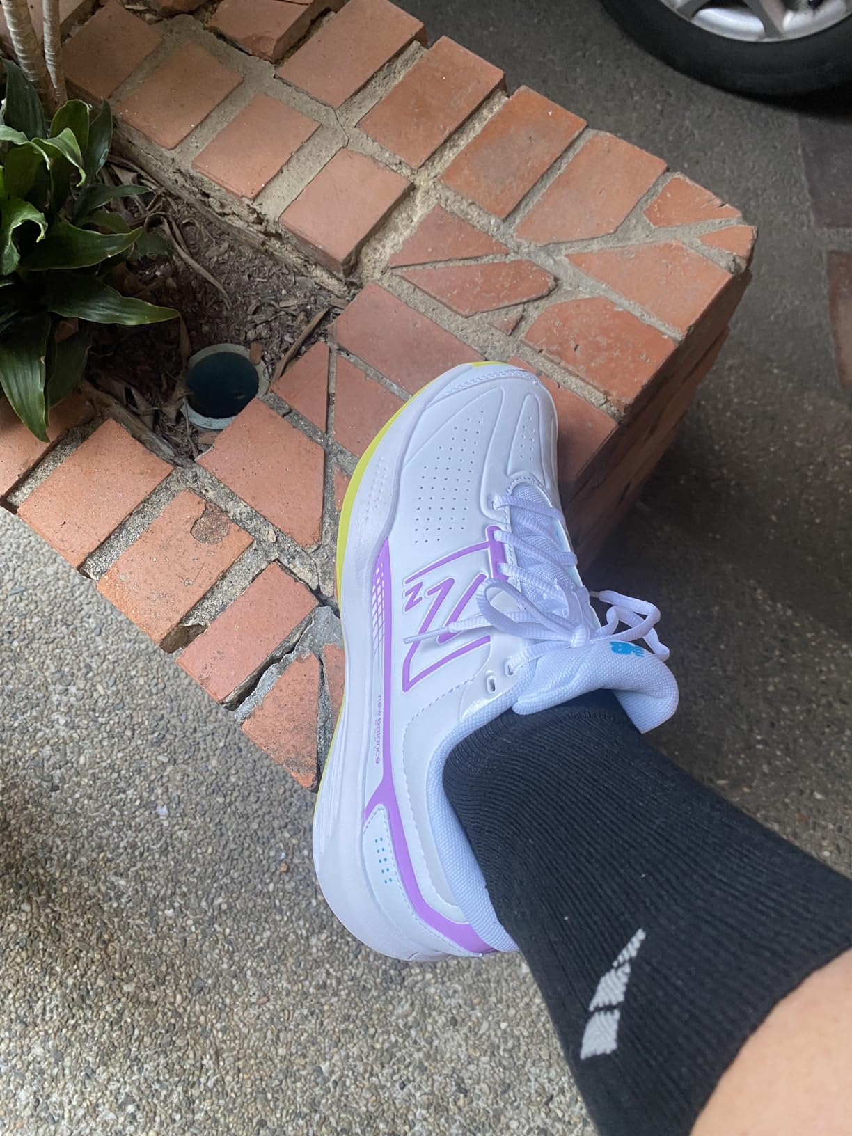 Woman playing tennis on court wearing New Balance 696 V5 shoes