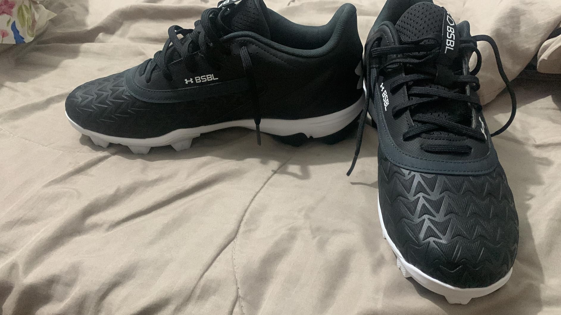 Under Armour Leadoff Low RM 3.0 on grass baseball field showing molded rubber cleat traction during play