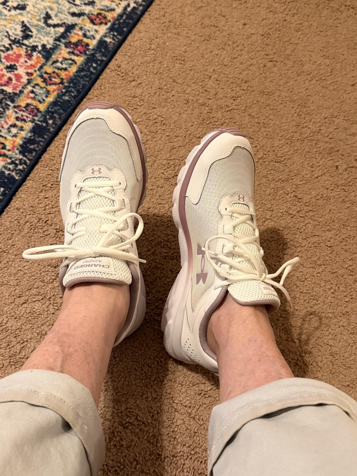 Under Armour Charged Assert 9 in white and mauve pink colorway showing clean elegant design