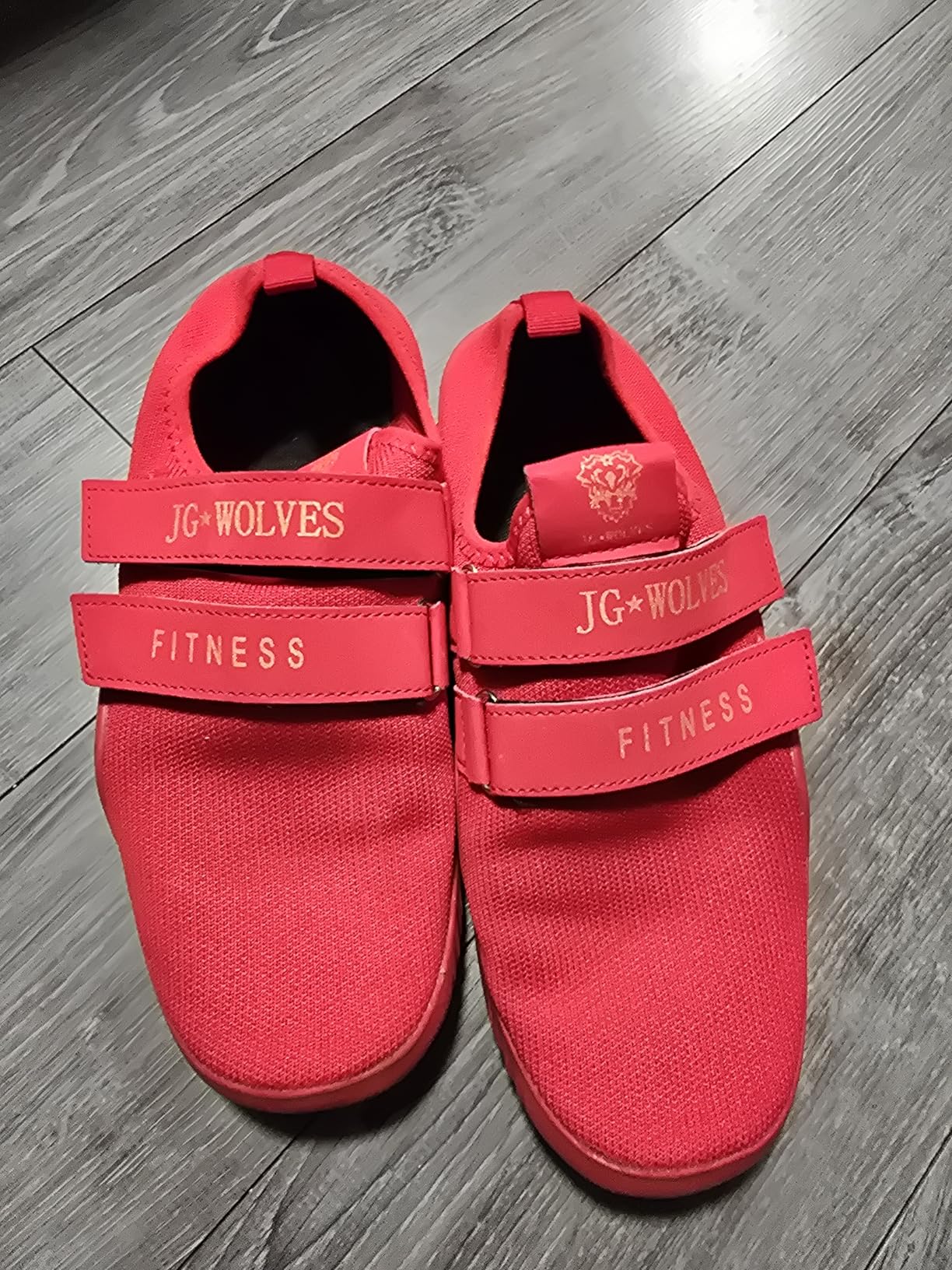 Close-up view of pink fitness deadlift shoes showing the stretchy upper material and dual velcro strap closure system