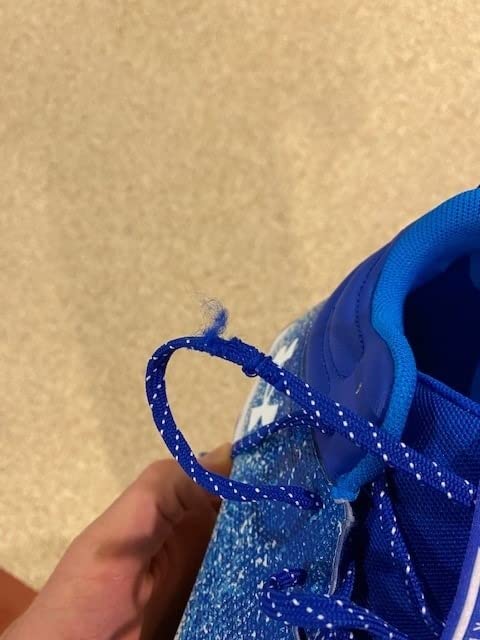 Detailed view of Under Armour Spotlight cleat sole showing molded rubber cleat pattern and full-length EVA midsole construction