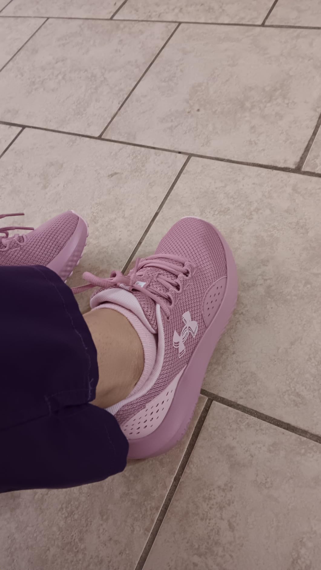 Under Armour Women's Charged Surge 4 pink blush colorway showing breathable polyester mesh upper construction and lace-up design