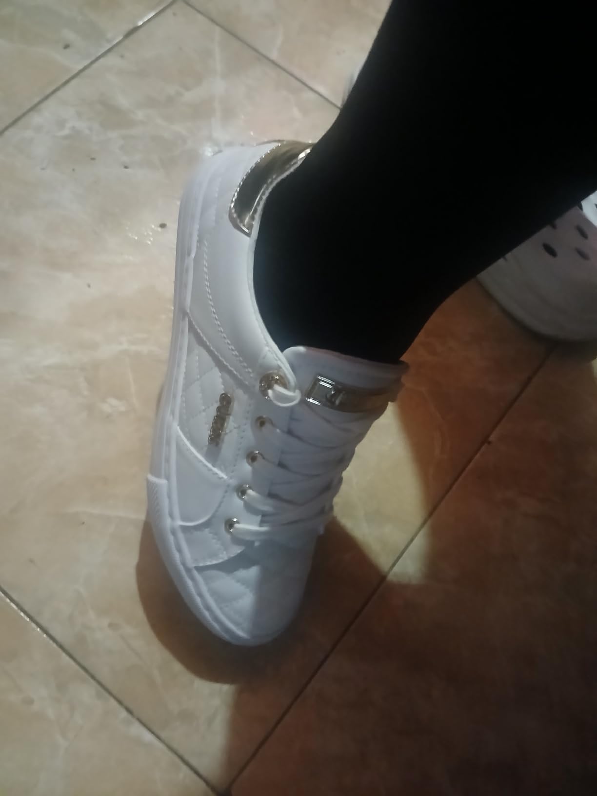 GUESS Women's Loven Sneaker close-up showing logo hardware detail and quilted texture pattern
