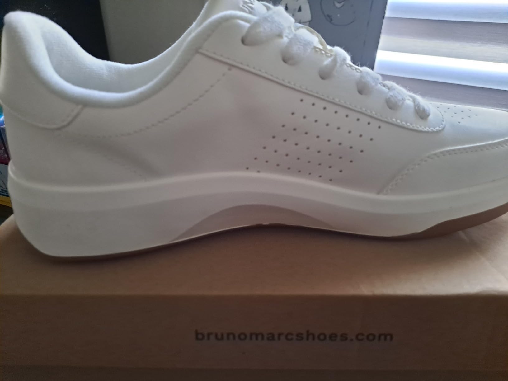 Close-up of Bruno Marc sneaker showing perforated PU upper construction, padded collar, and lacing detail