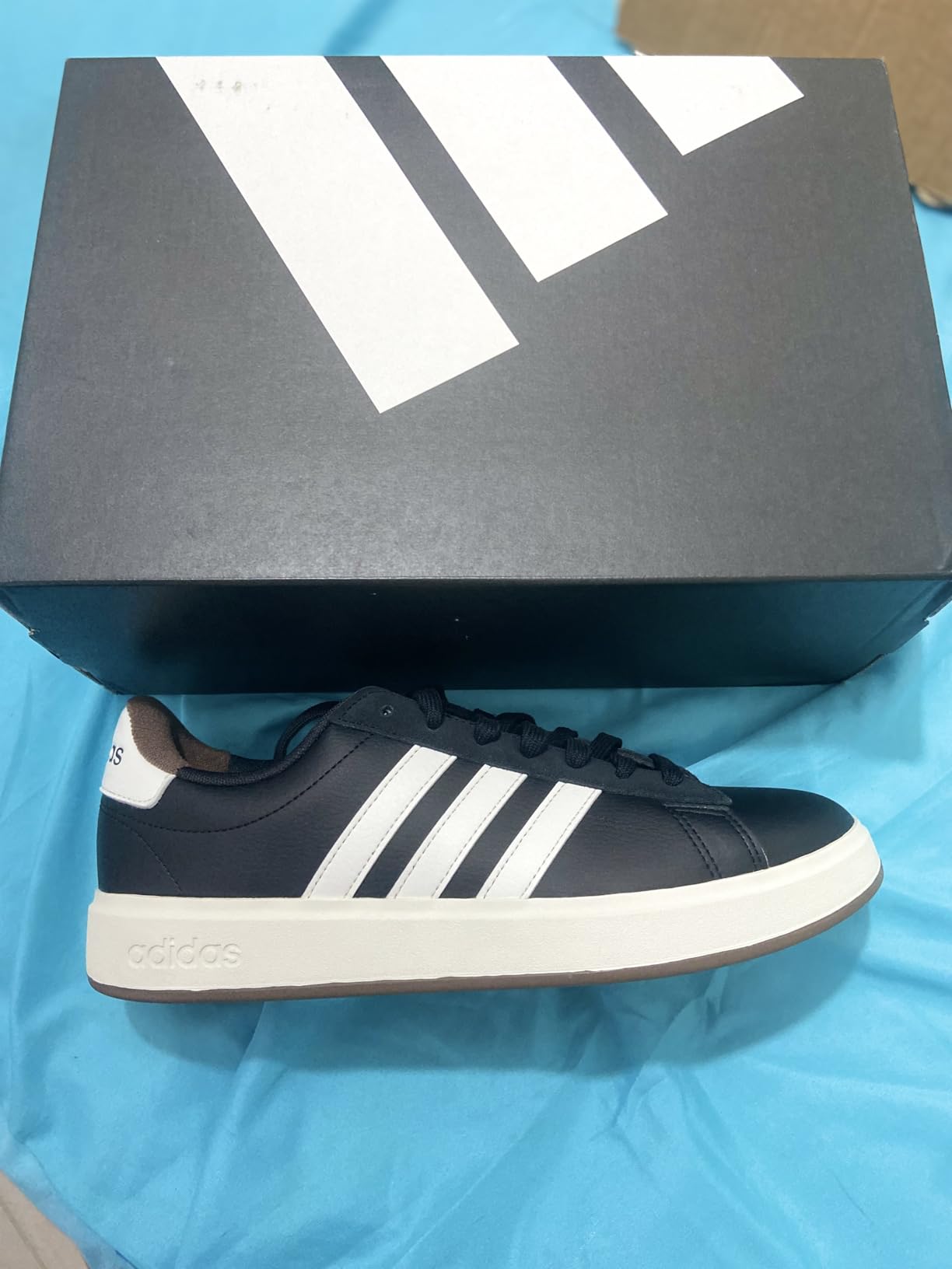 Adidas Grand Court 2.0 side profile showing three stripes stitching and synthetic leather upper construction