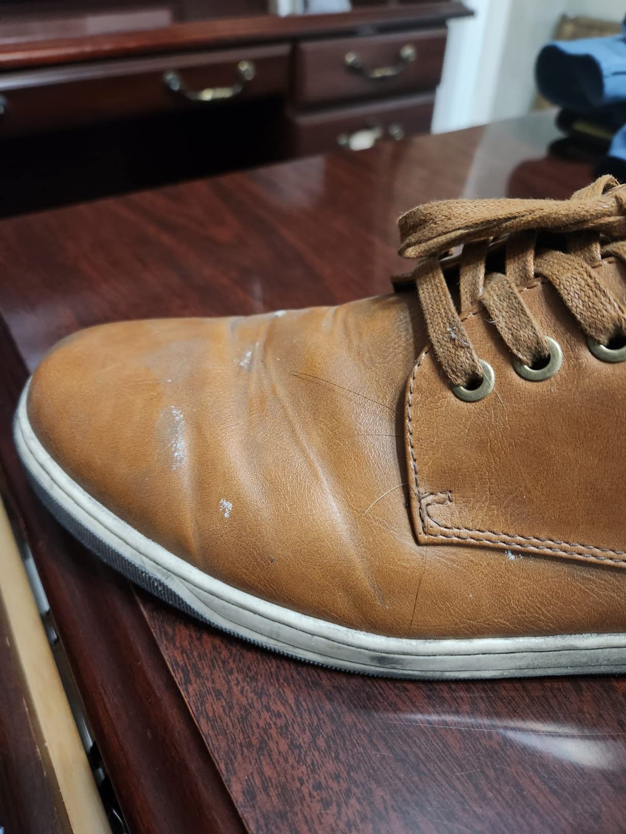 Durability failure showing cracking at ball of foot flex point on Jousen faux leather upper with visible stress damage