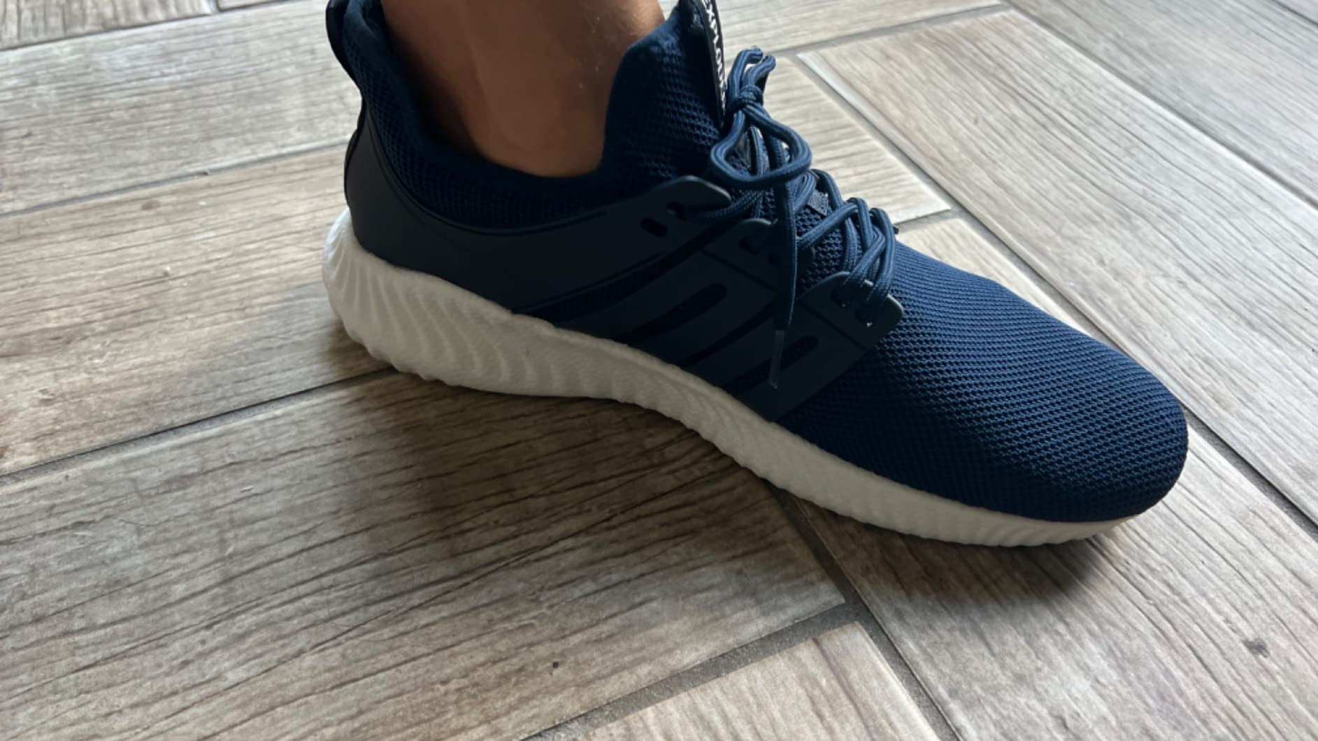 AKK sneakers navy blue colorway worn on feet showing fit profile and low-top silhouette