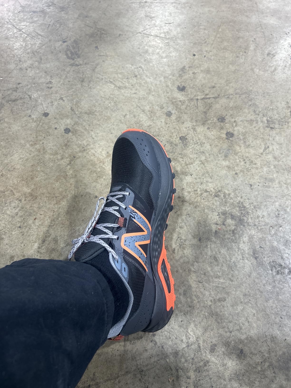 New Balance MT410 V8 showing orange and black colorway with construction detail visible