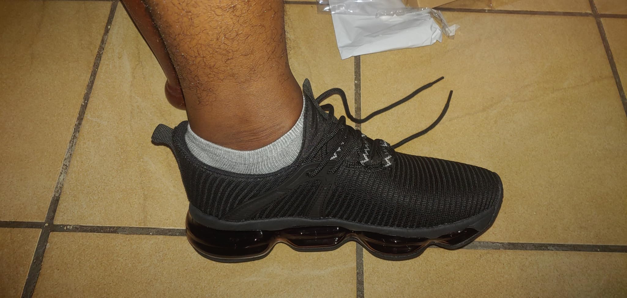 Socviis Men's Air Running Shoes sizing fit demonstration on foot showing narrow width profile that commonly affects wider-footed users