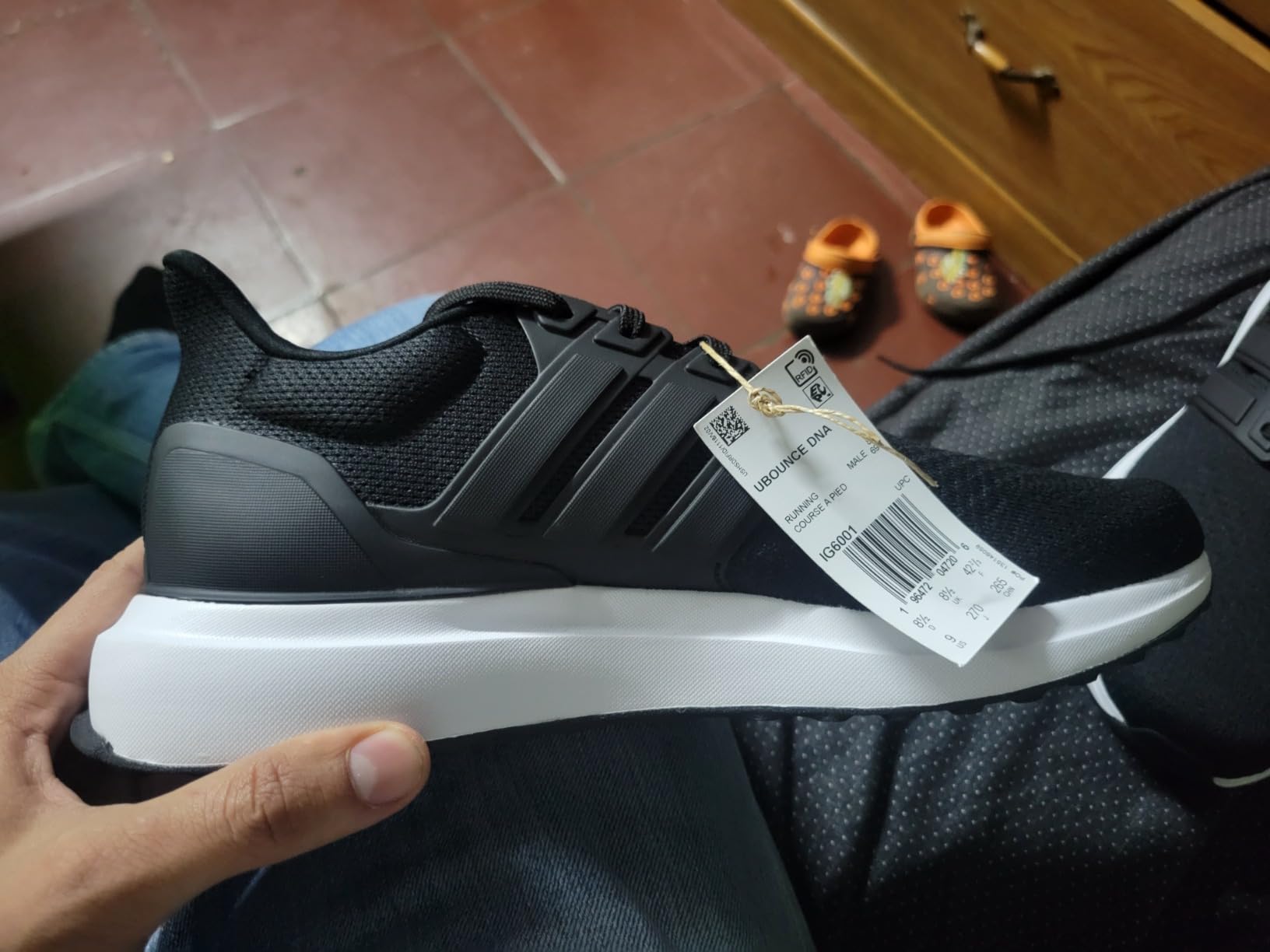 Adidas Men's Ubounce DNA sneakers black colorway full view showing knit upper and clean silhouette