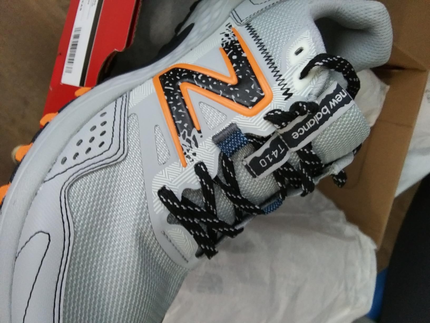 Close-up of New Balance MT410 V8 synthetic upper showing mesh panels and TPU overlay construction