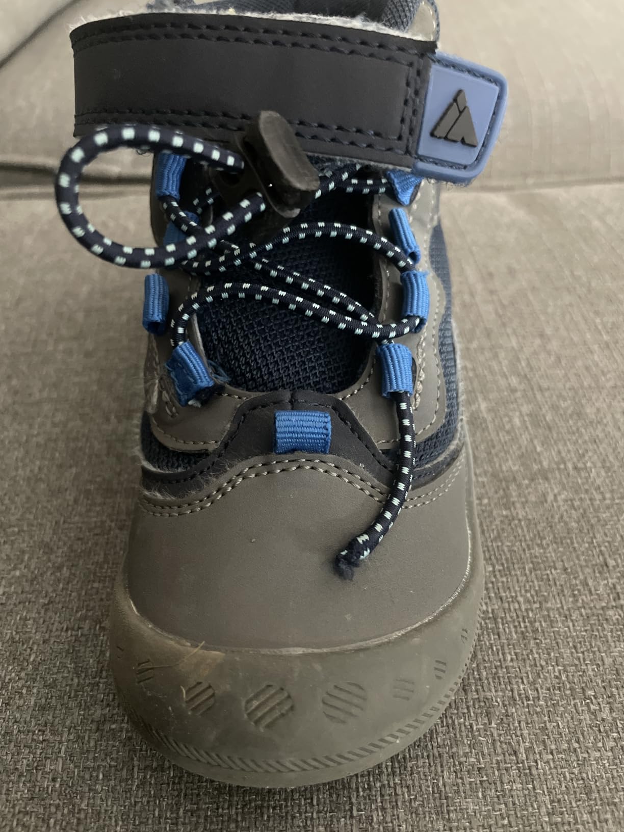 Detail view of Mishansha kids hiking boot closure area showing wear patterns from regular use