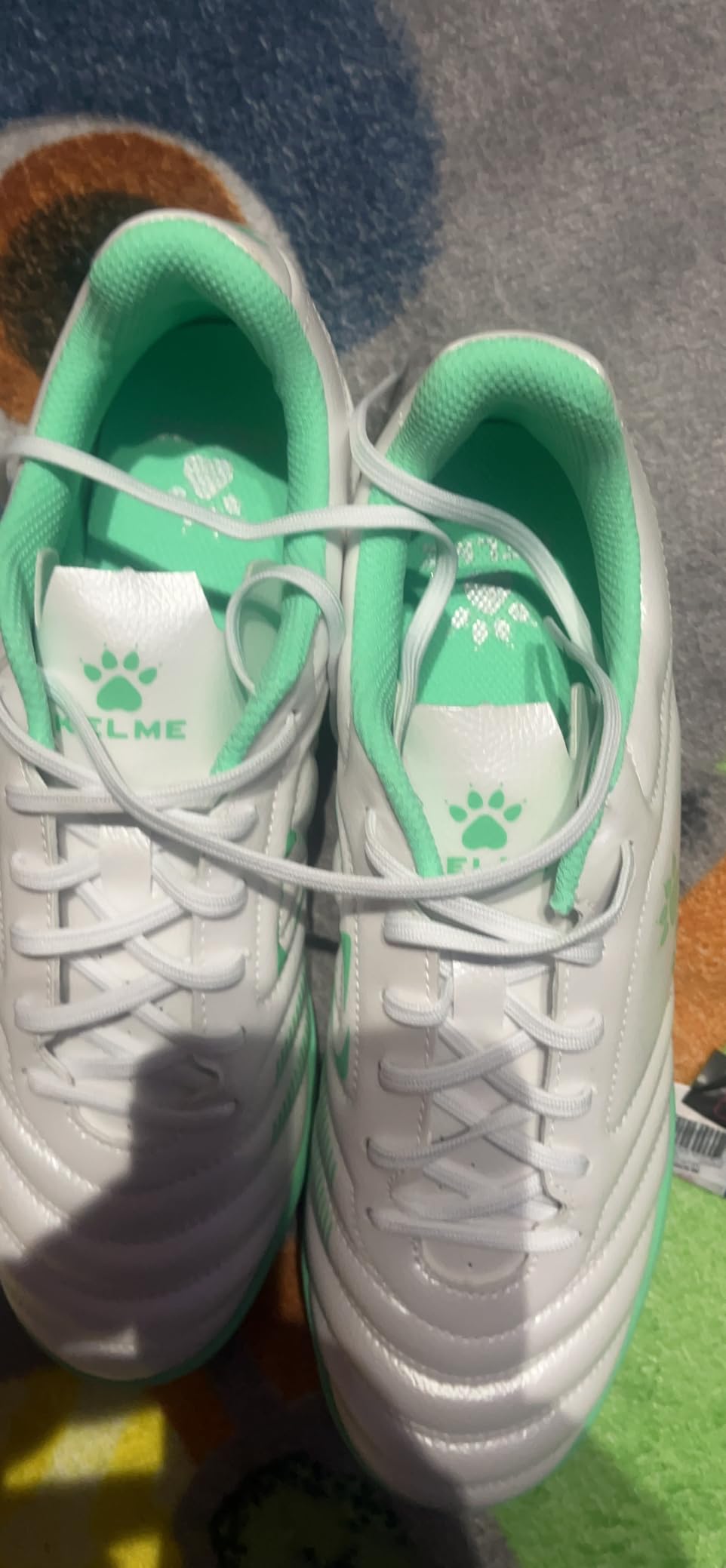 Final product shot of KELME turf soccer cleats showing overall design and value proposition for budget-conscious players