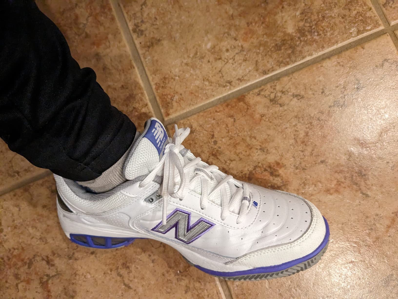 New Balance Women's 806 V1 Tennis Shoe in white with purple accents on court surface