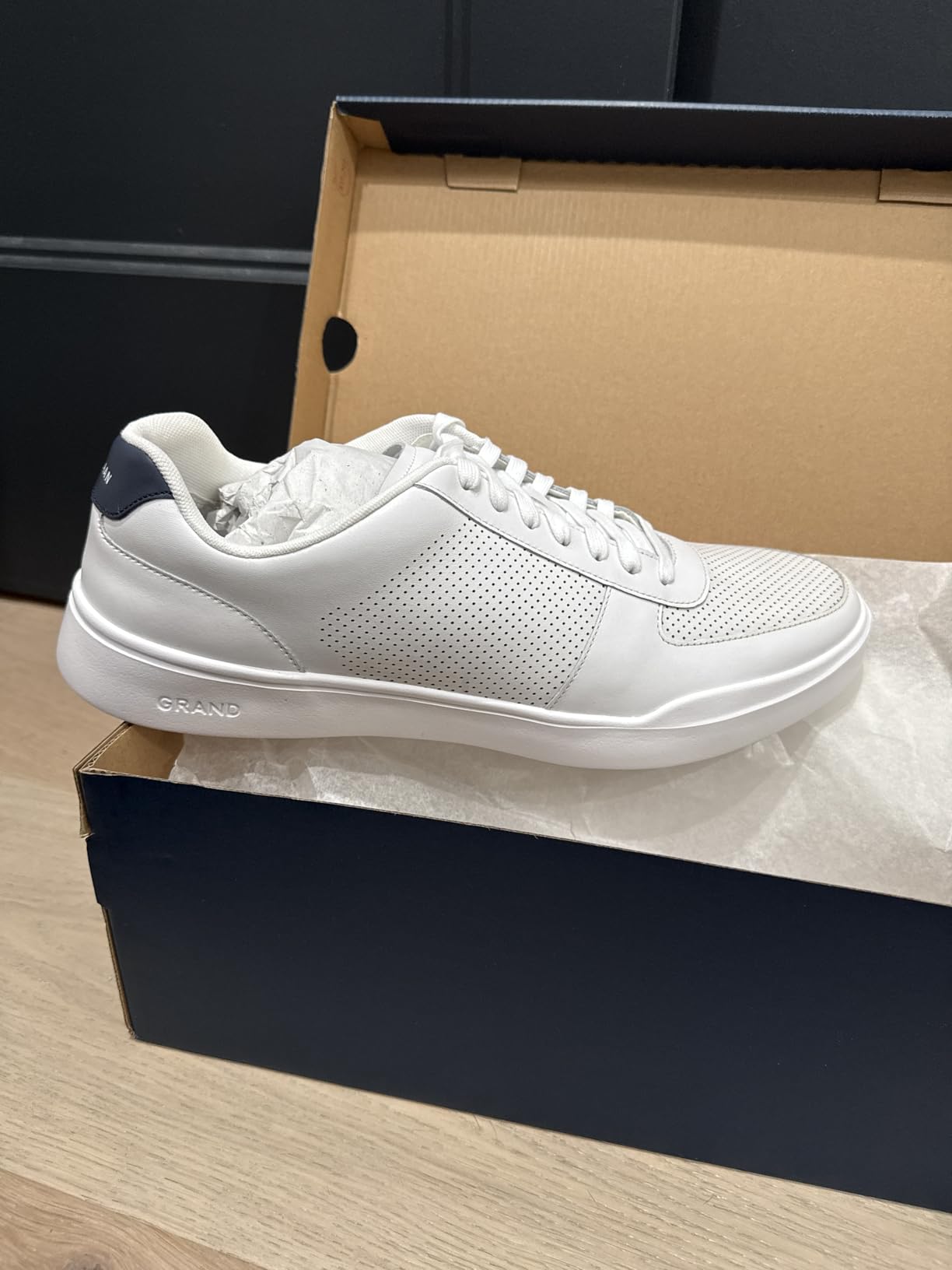 Side profile view of Cole Haan Grand Crosscourt Modern Perforated showing low silhouette and heel tab design