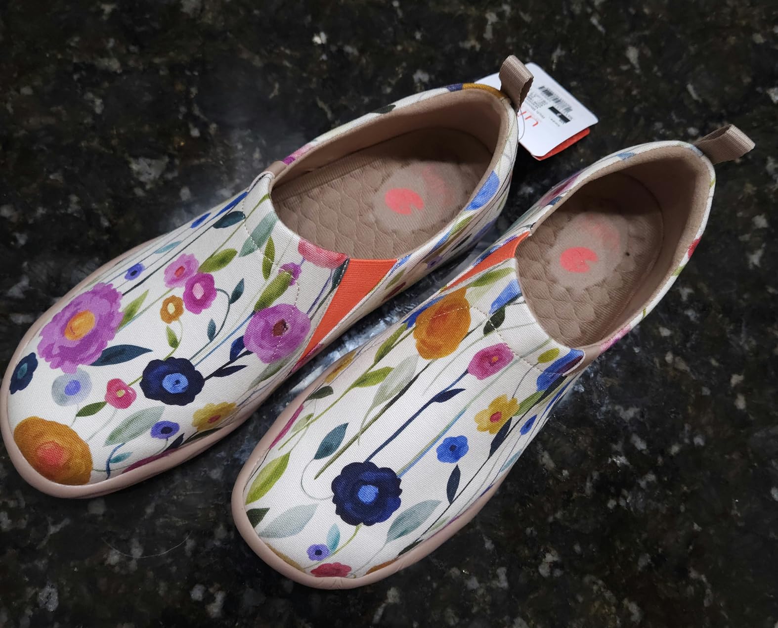 Close-up detail of UIN Blossom canvas upper showing heat-set painted floral design and slip-on construction quality