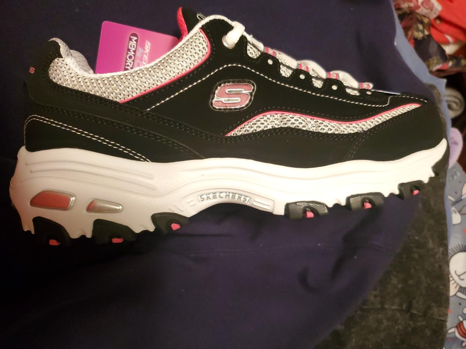 Top-down view of the Skechers D'Lites showing padded tongue and lacing system with extra laces nearby.