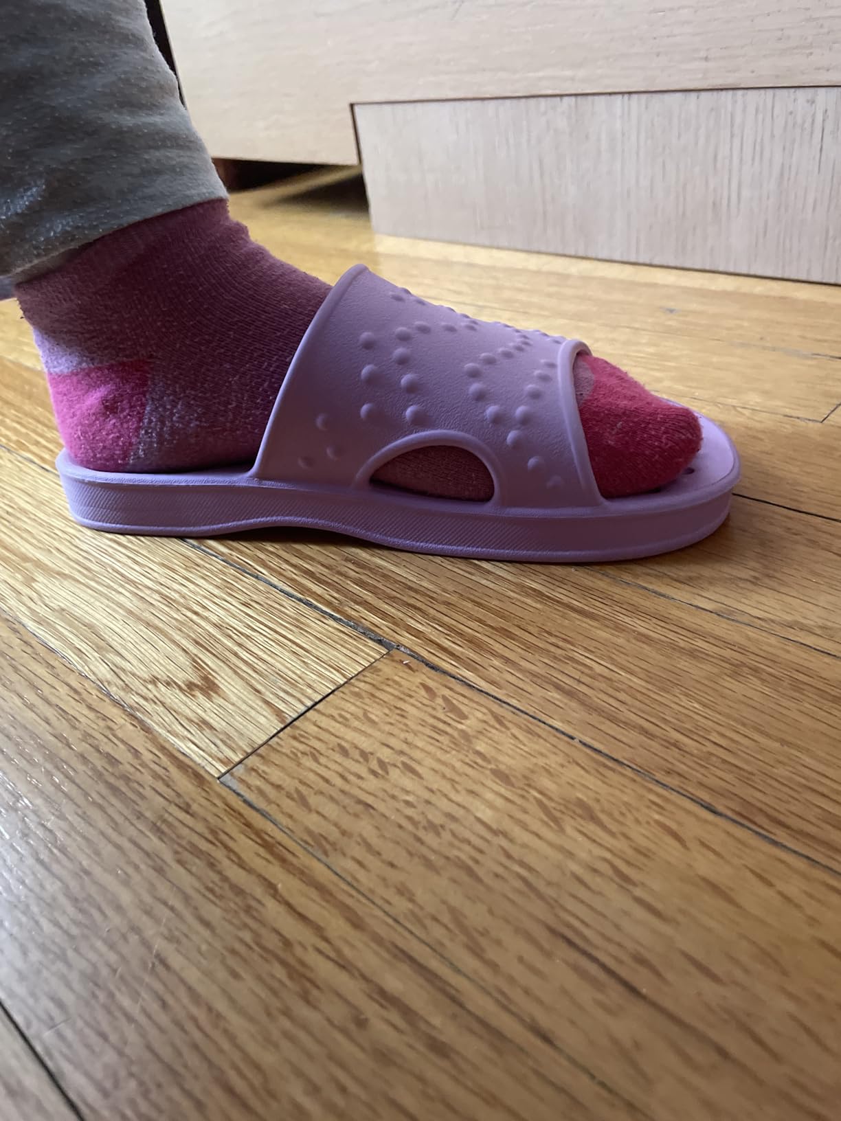 Close-up of shevalues shower shoes showing full-footbed drain hole pattern and EVA construction detail