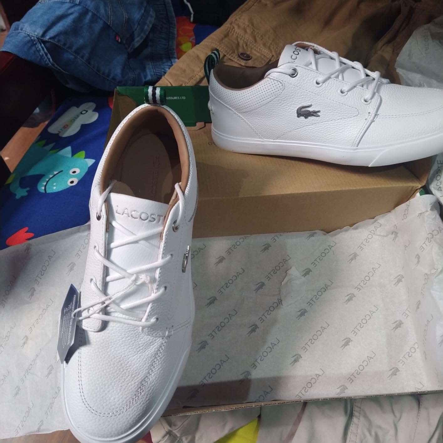 Side profile of Lacoste Bayliss sneaker showing leather and suede construction detail with crocodile branding on quarter panel
