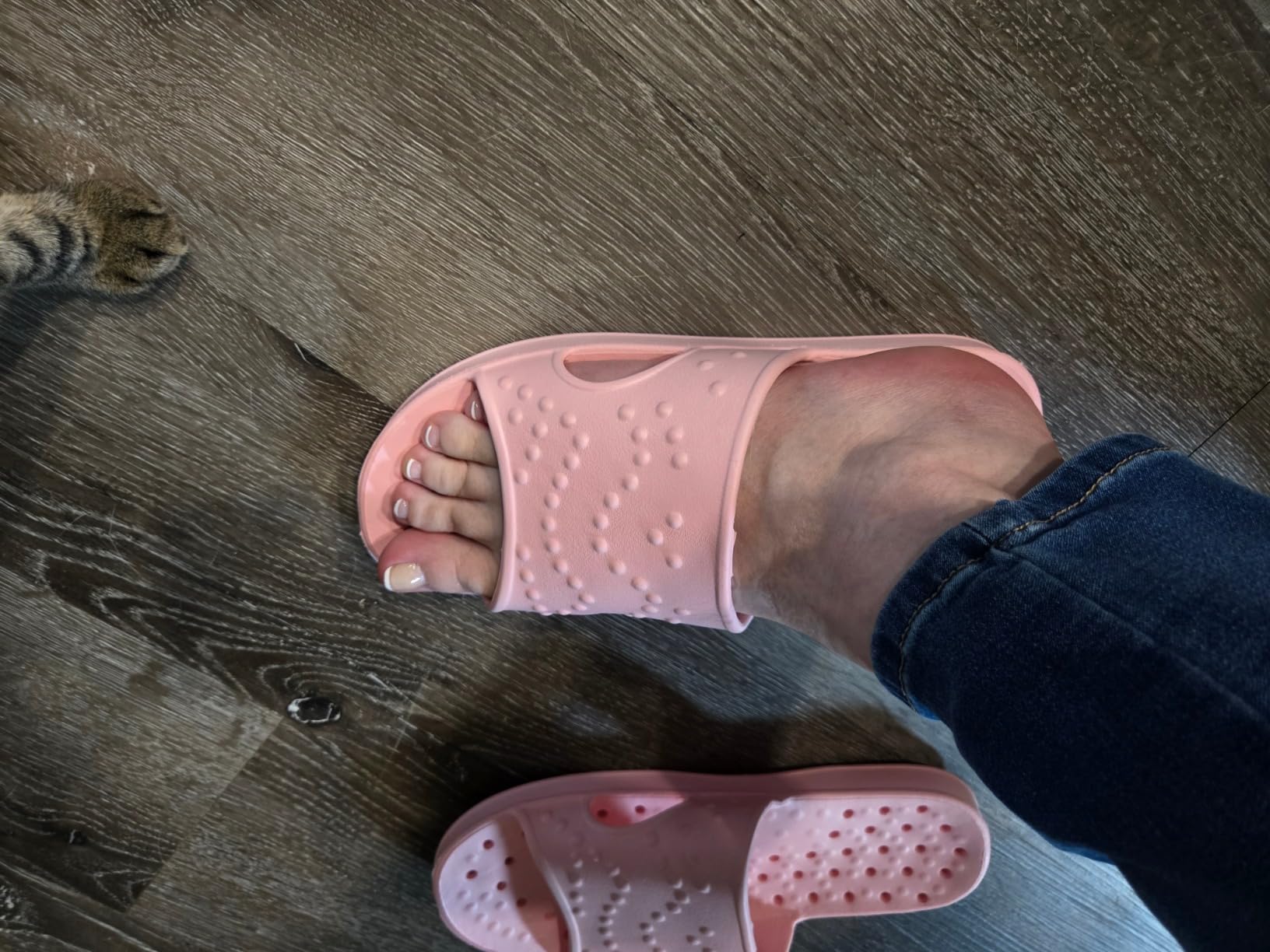 Pair of shevalues shower shoes on wet pool deck showing water drainage in action