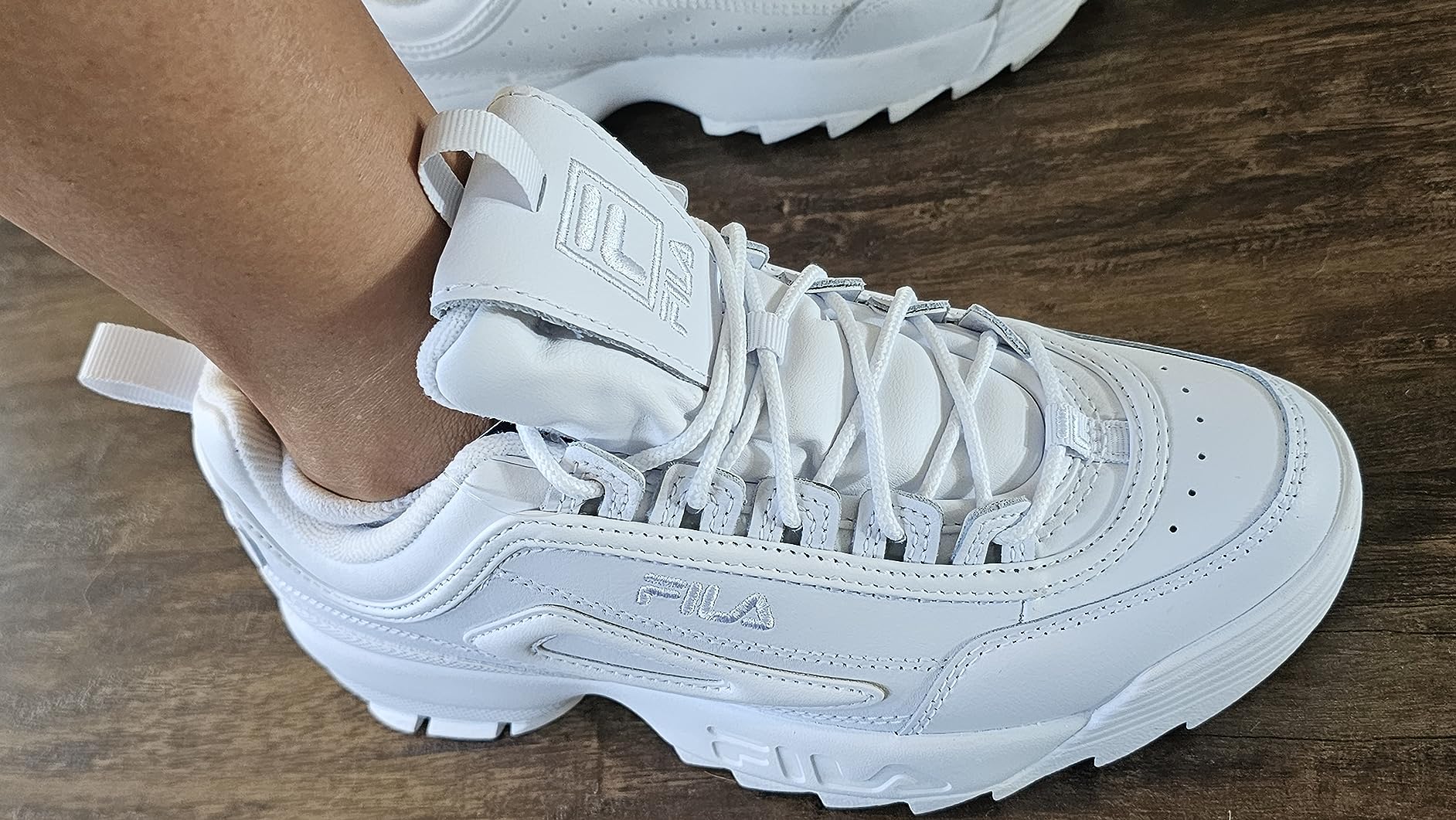 Fila Disruptor II lacing system detail showing padded ankle collar, tongue construction, and leather eyelet design