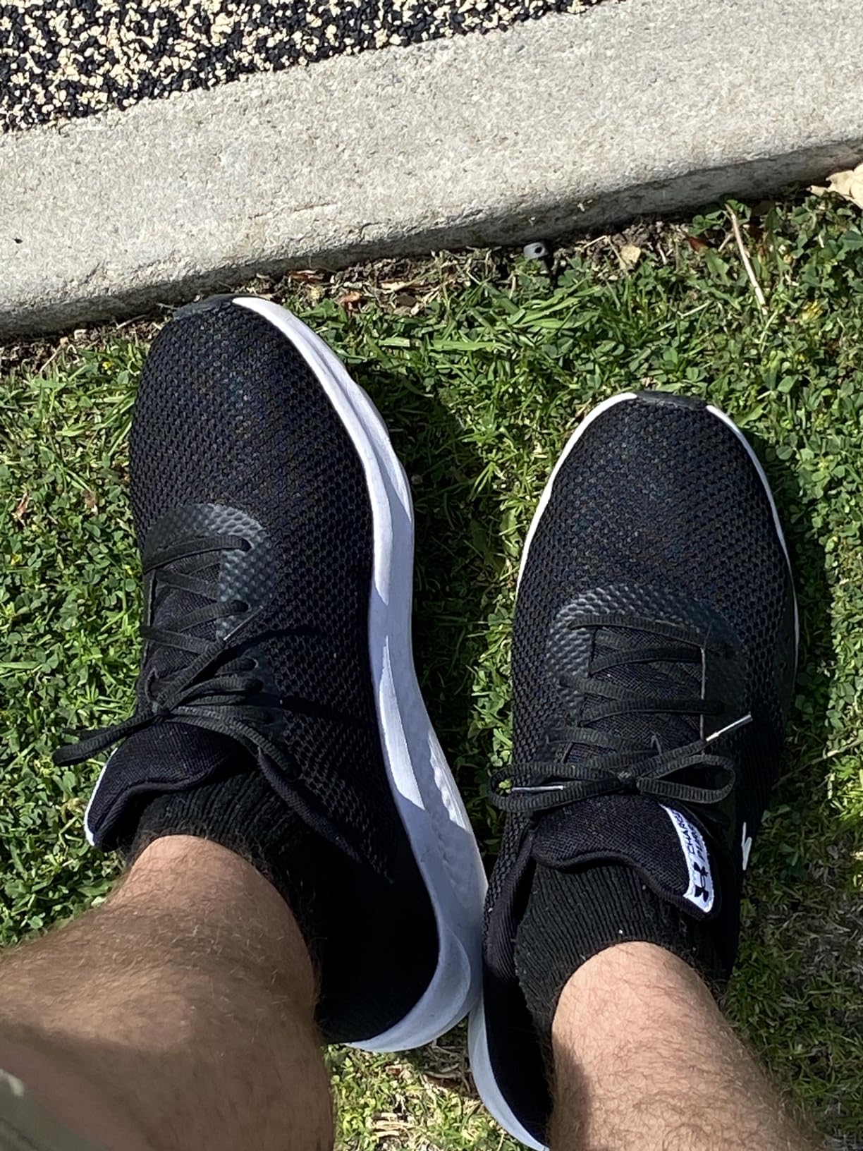 Close-up of Under Armour Charged Pursuit 3 mesh upper construction showing synthetic midfoot overlays