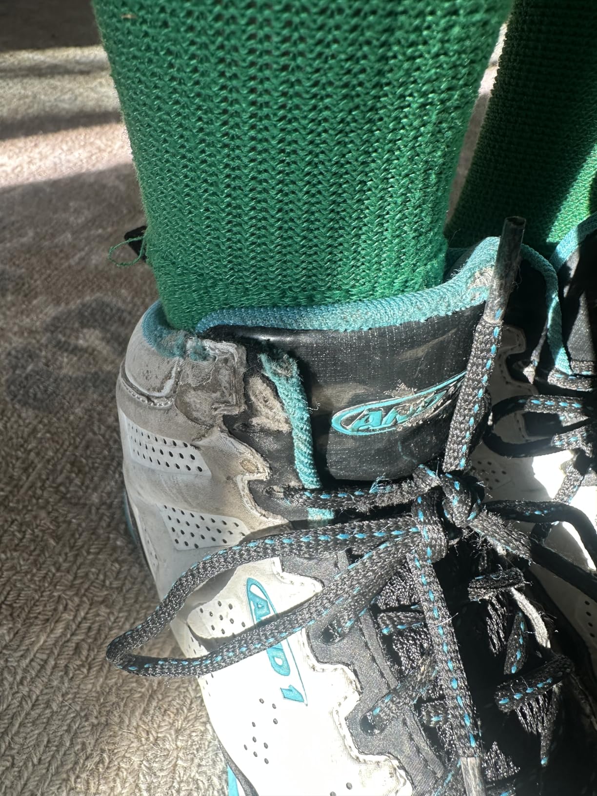 Close-up view of AND1 Showout synthetic upper construction and lacing system on youth basketball high top