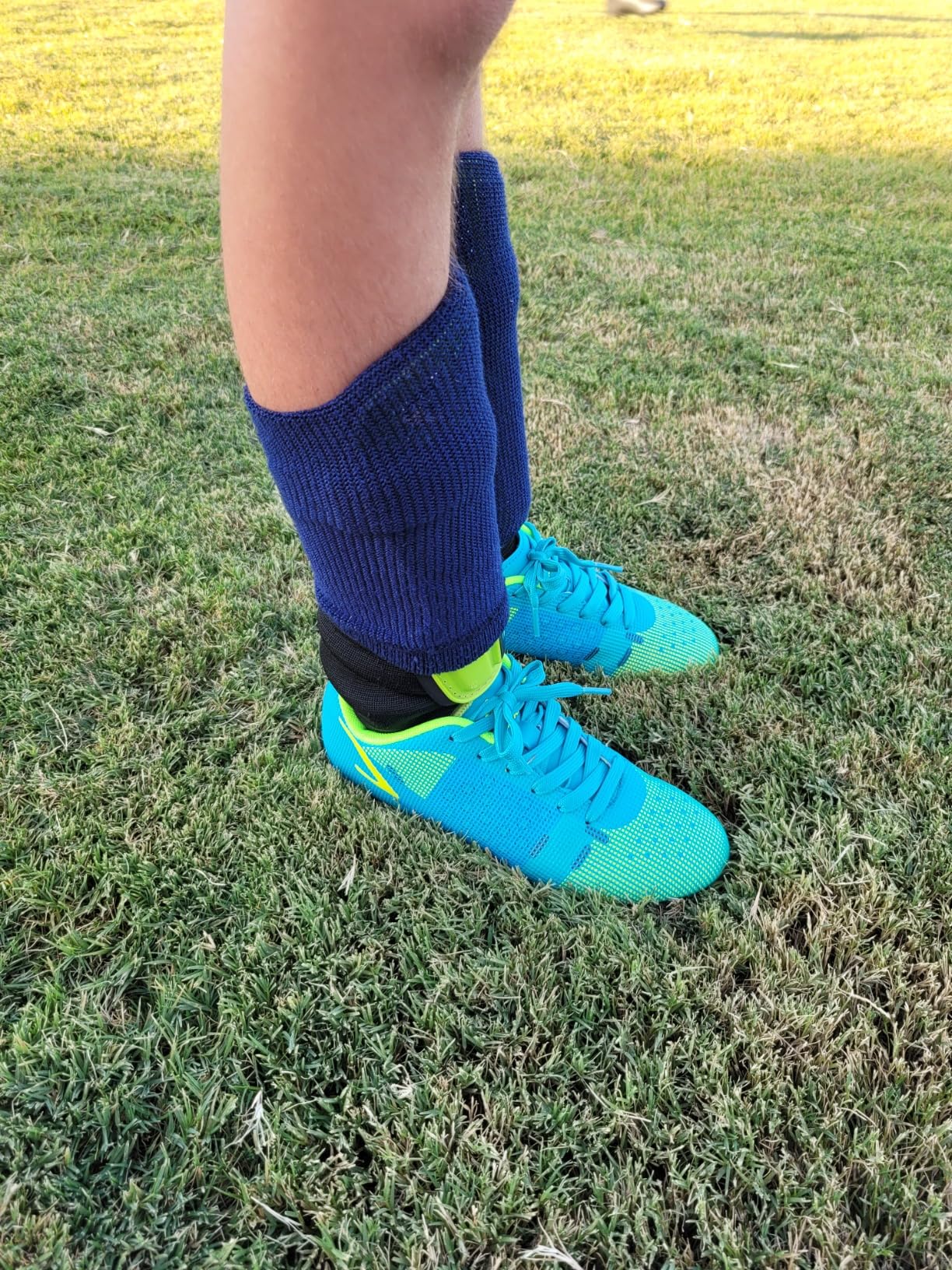 Kids soccer cleats in action during youth recreational league soccer practice on grass field