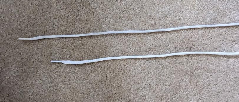 Close-up of ASICS Upcourt 5 lacing system showing notably short included shoelaces