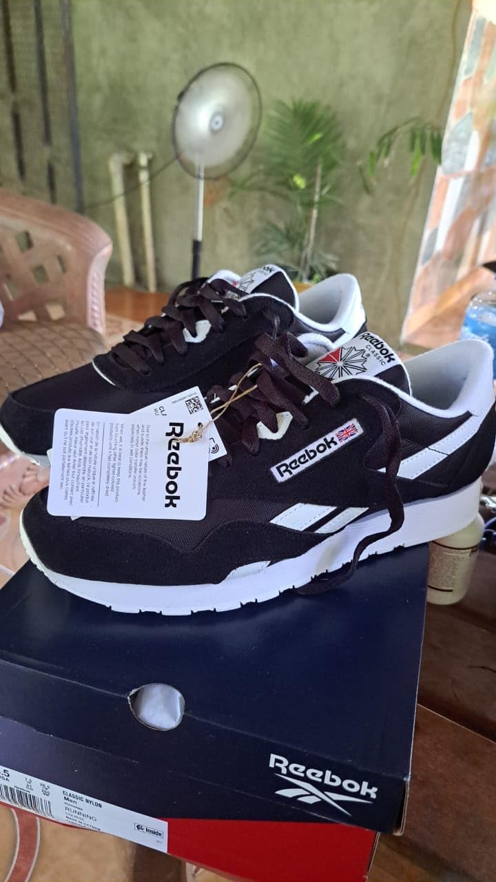Close-up view of Reebok Classic sneaker toe box and lacing showing nylon upper and suede overlay construction