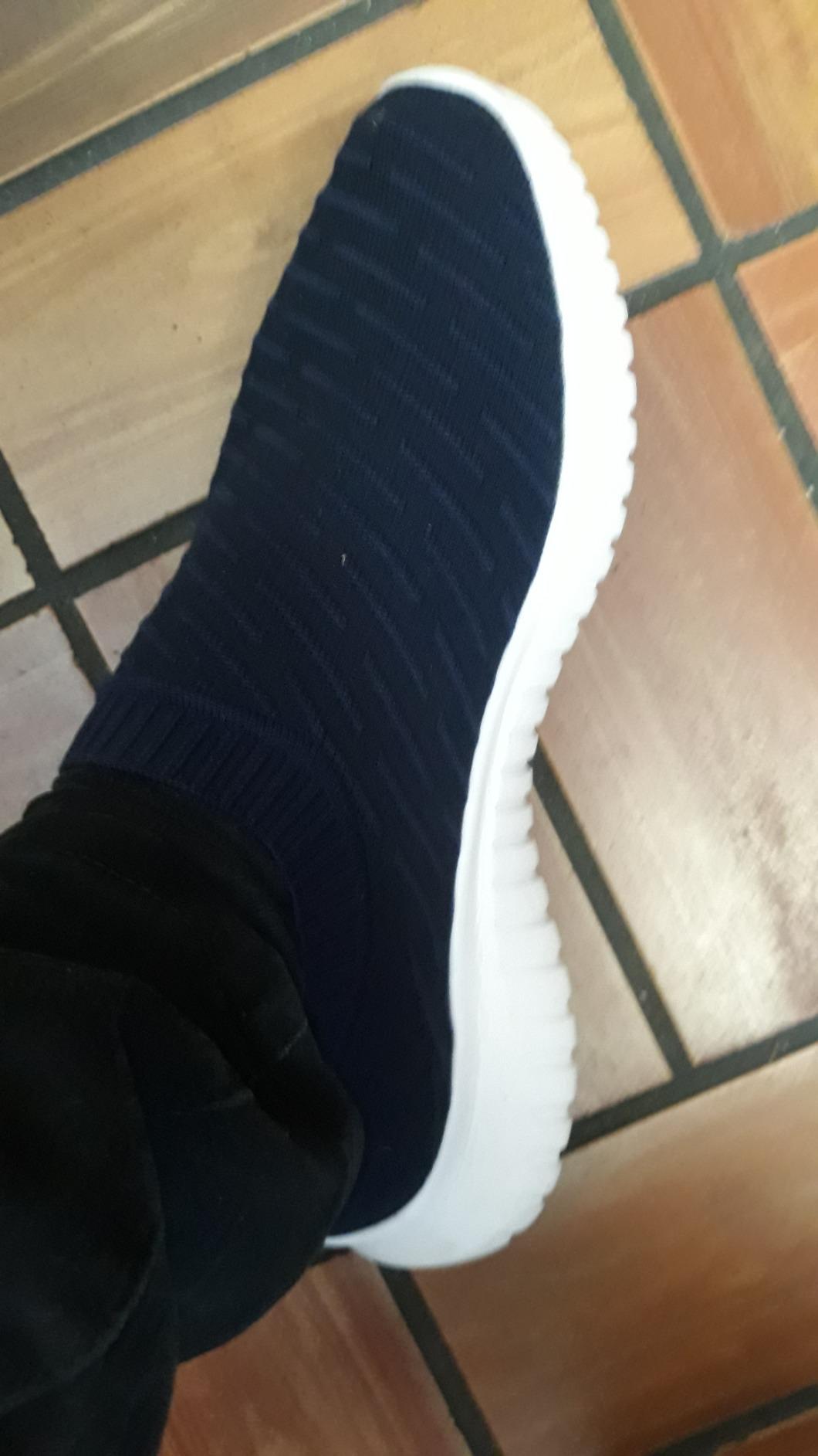 Close-up of Konhill men's walking shoes showing knit upper texture and slip-on design with heel pull loop