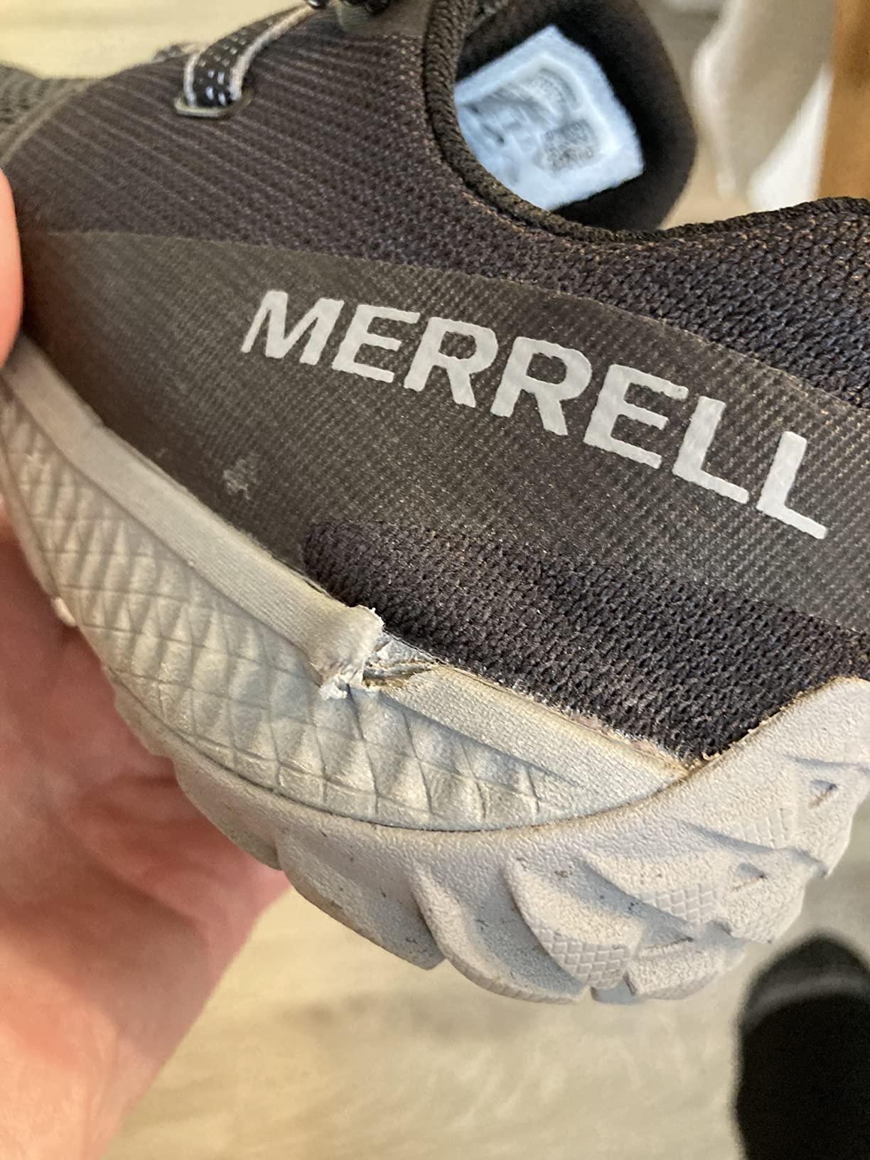 Close-up photograph showing potential outsole separation at heel area of Merrell Trail Glove 6 after testing