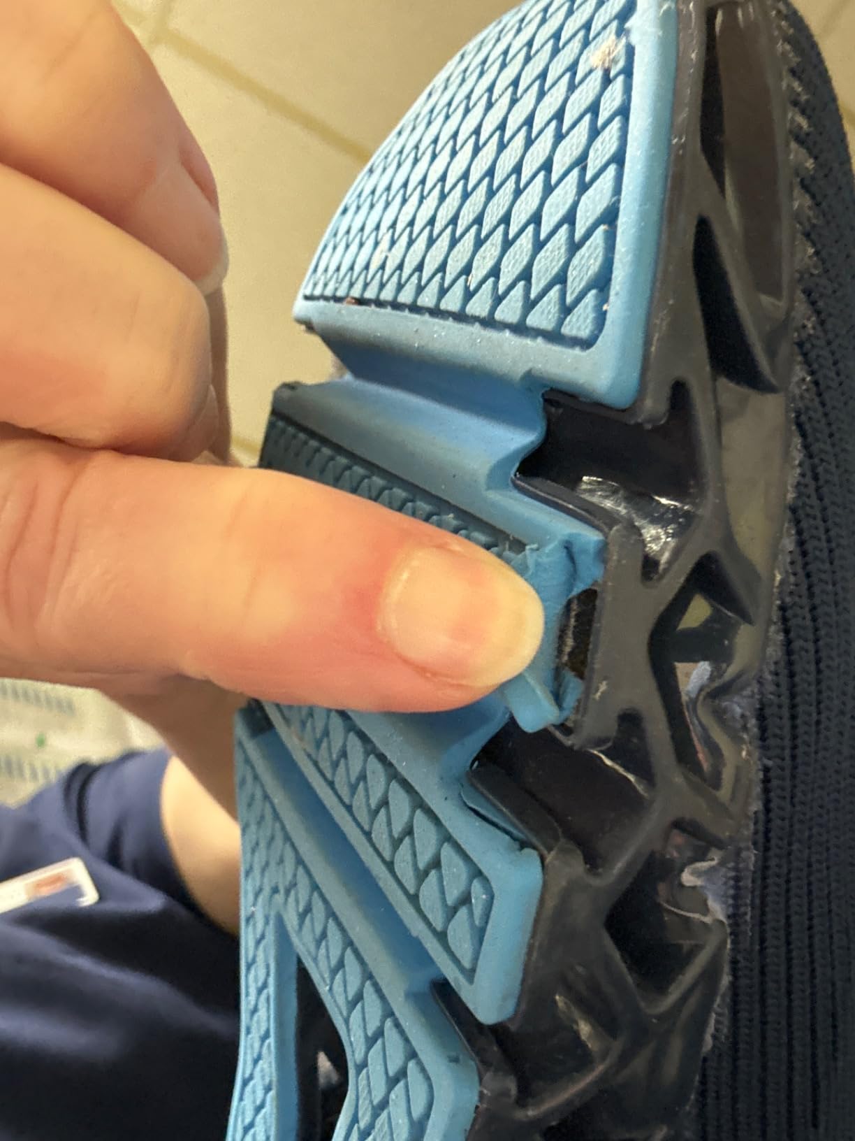 Close-up of SKDOIUL shoe sole peeling showing adhesive failure between TPU outsole and mesh upper at flex point