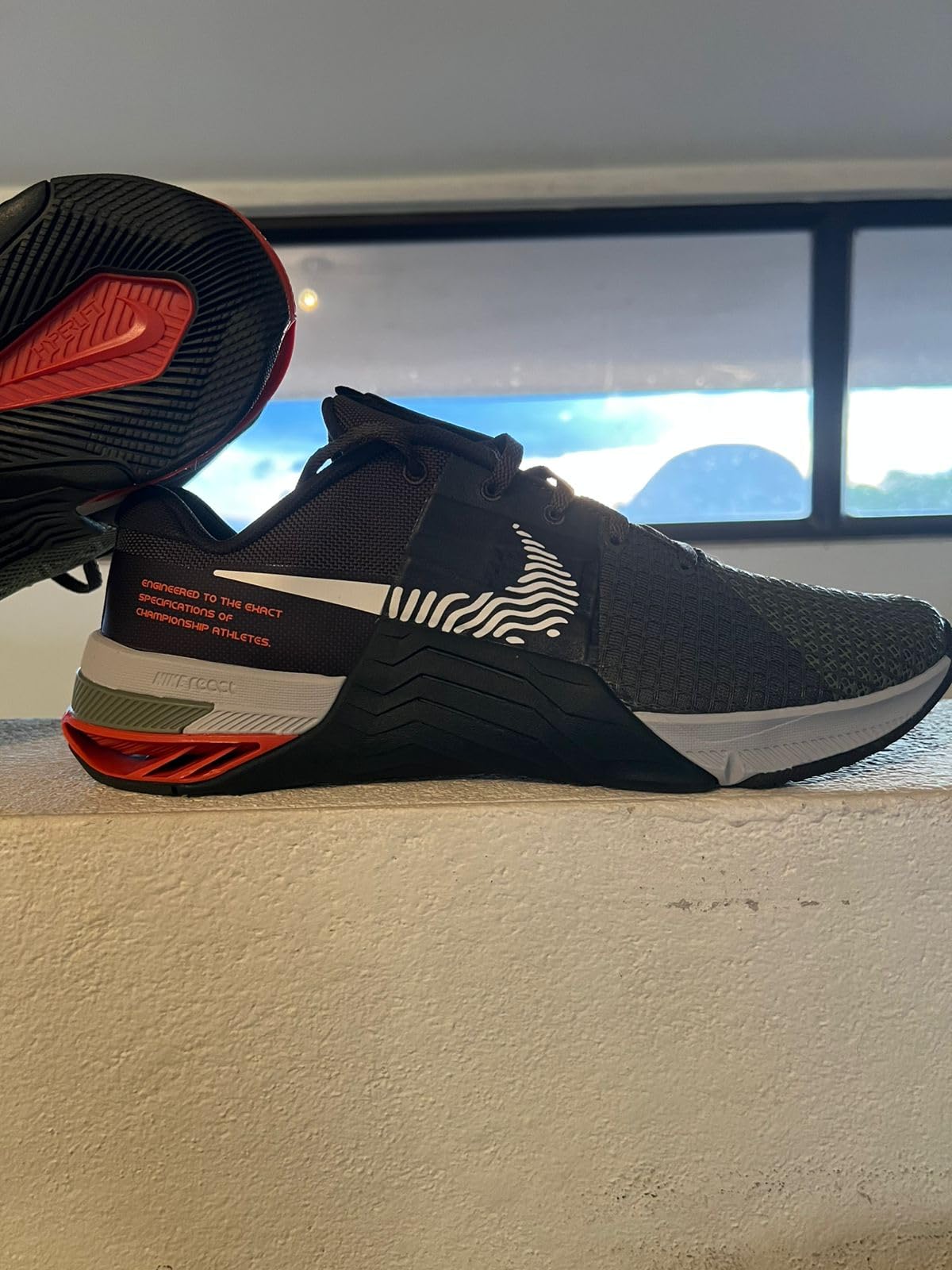Nike Metcon 8 men's training shoes in black and red colorway showing mesh upper and rubber outsole