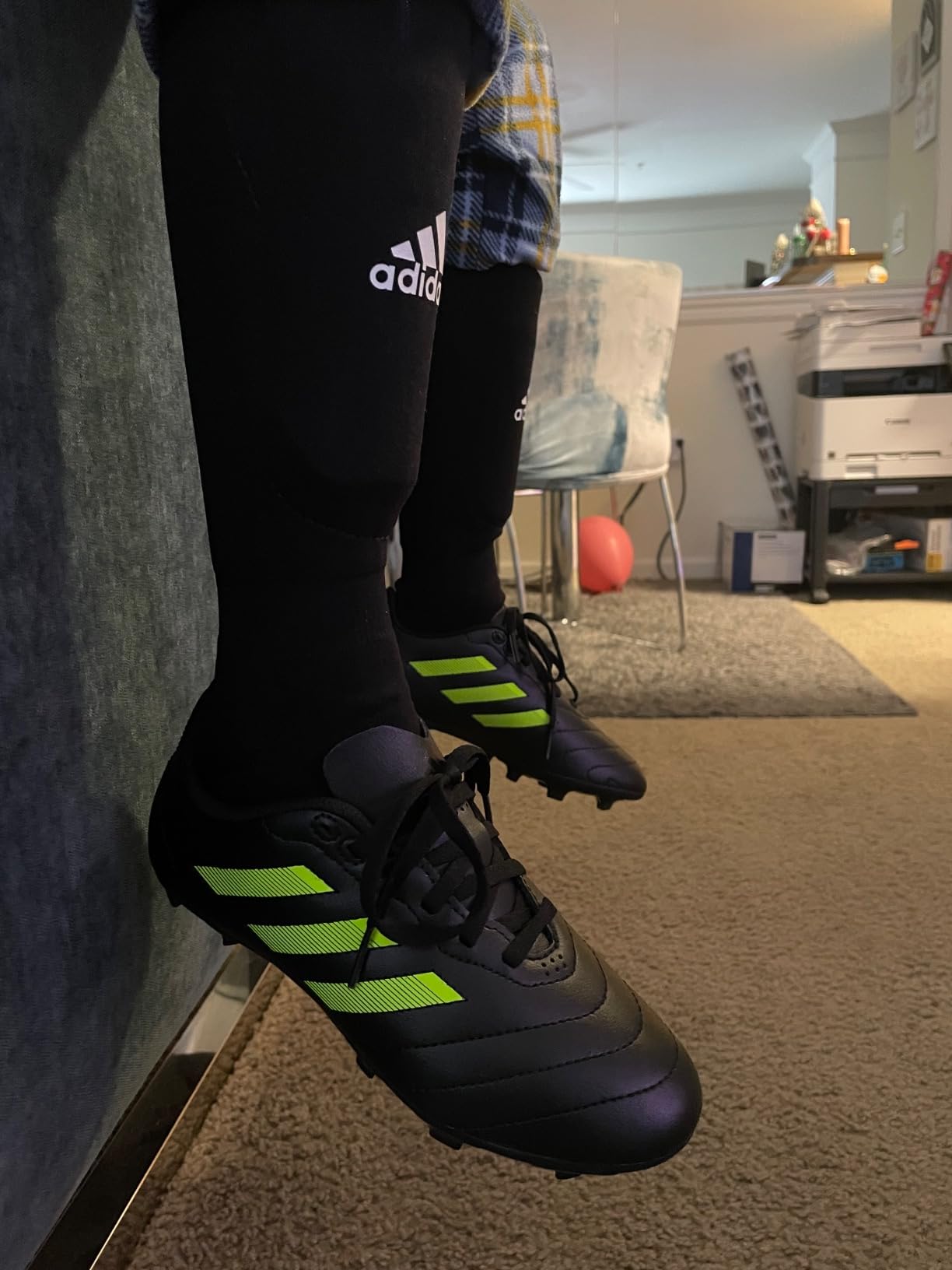 Kids wearing Adidas Goletto VII FG cleats during soccer practice on natural grass field