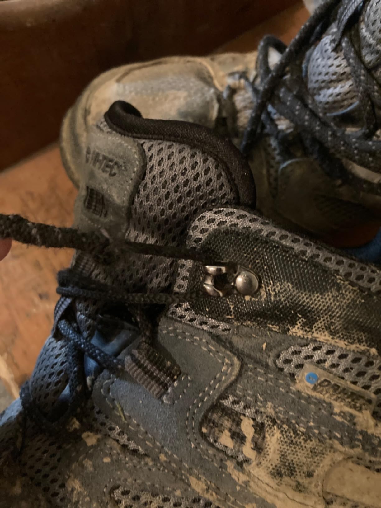 Close-up of metal lacing eyelets showing design flaw that causes accelerated lace wear