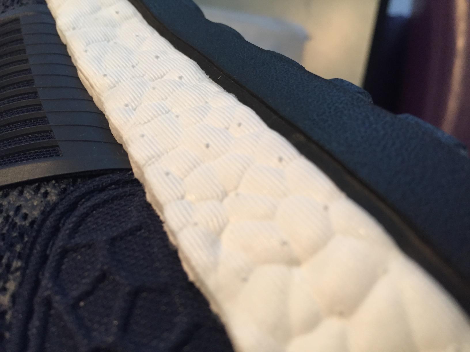 Close-up of Adidas Pureboost ZG engineered mesh upper construction showing the lacing panel and texture detail
