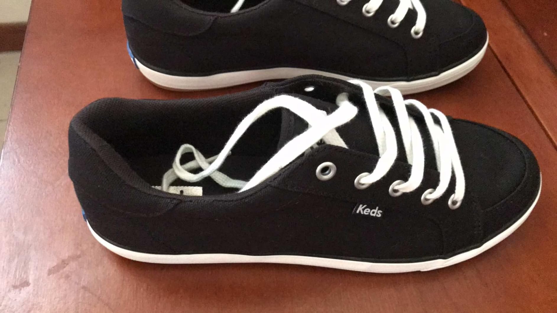 Keds sneaker side profile showing chambray canvas texture and extended lacing system detail